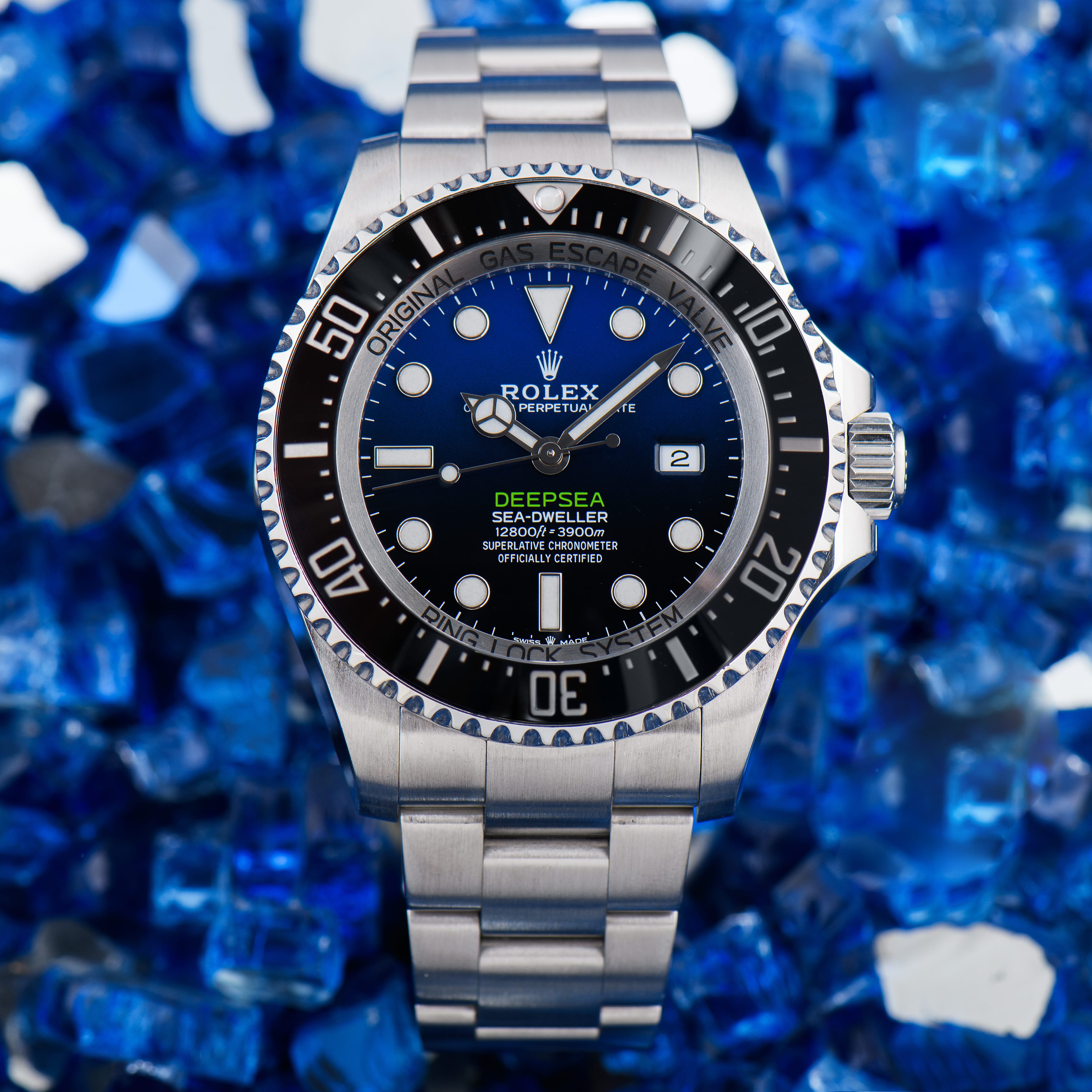 A genuine Rolex Sea-Dweller Deepsea with a D-blue dial, shown dial-forward on a blue crushed-glass background